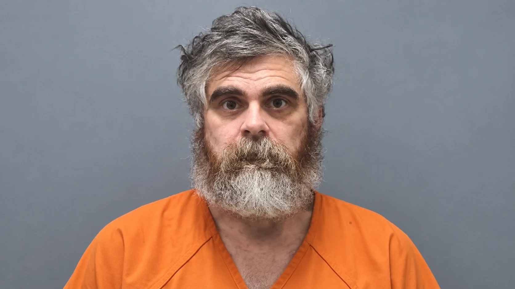 Booking portrait of BitBoy in an orange uniform
